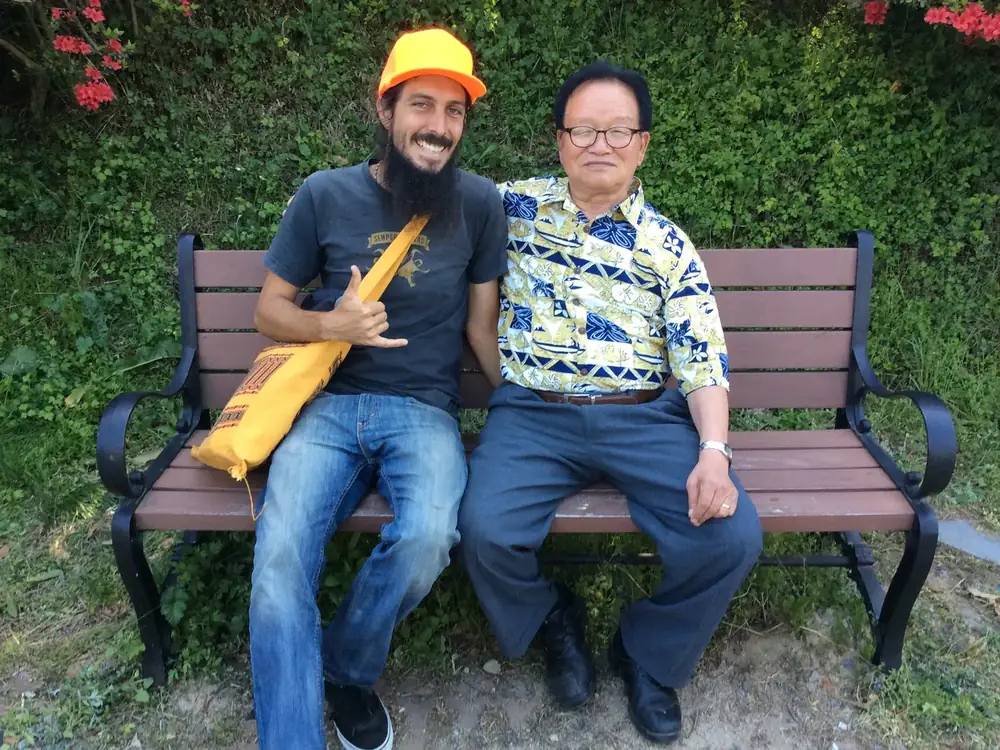 Drake Weinert sitting on a bench with Master Cho Han-kyu